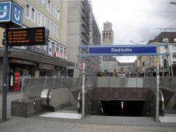 An entrance to the underground station. The surface tram stop for trams to Oberhausen, Abzweig Aktienstra�e and Hauptfriedhof is in the background