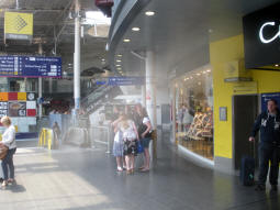 The lift to the Metrolink mezzanine level and platform B for trams to Ashton-under-Lyne (right) and escalators and stairs down to Metrolink and Fairfield Street (left), from the railway station concourse