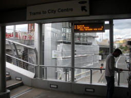 The entrance from the station footbridge features a tram departures display