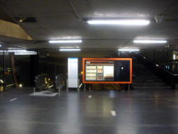 Escalator and stairs to the eastbound platform on the left, an exit on the right